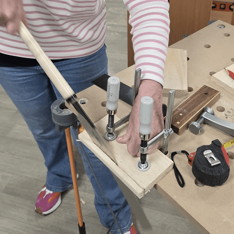 Diy classes for women showing a women using a wood saw