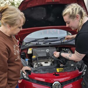 Showing Student how to check car oil